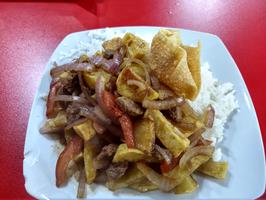 This is Lomo Saltado, a stir fry of beef, onions, tomatoes, and french fries on top of rice.